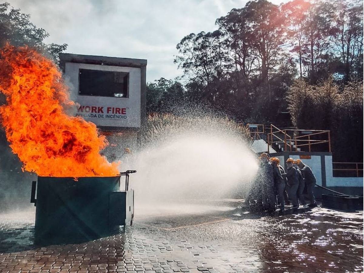 Equipe combatendo fogo em contêiner com jato de água
